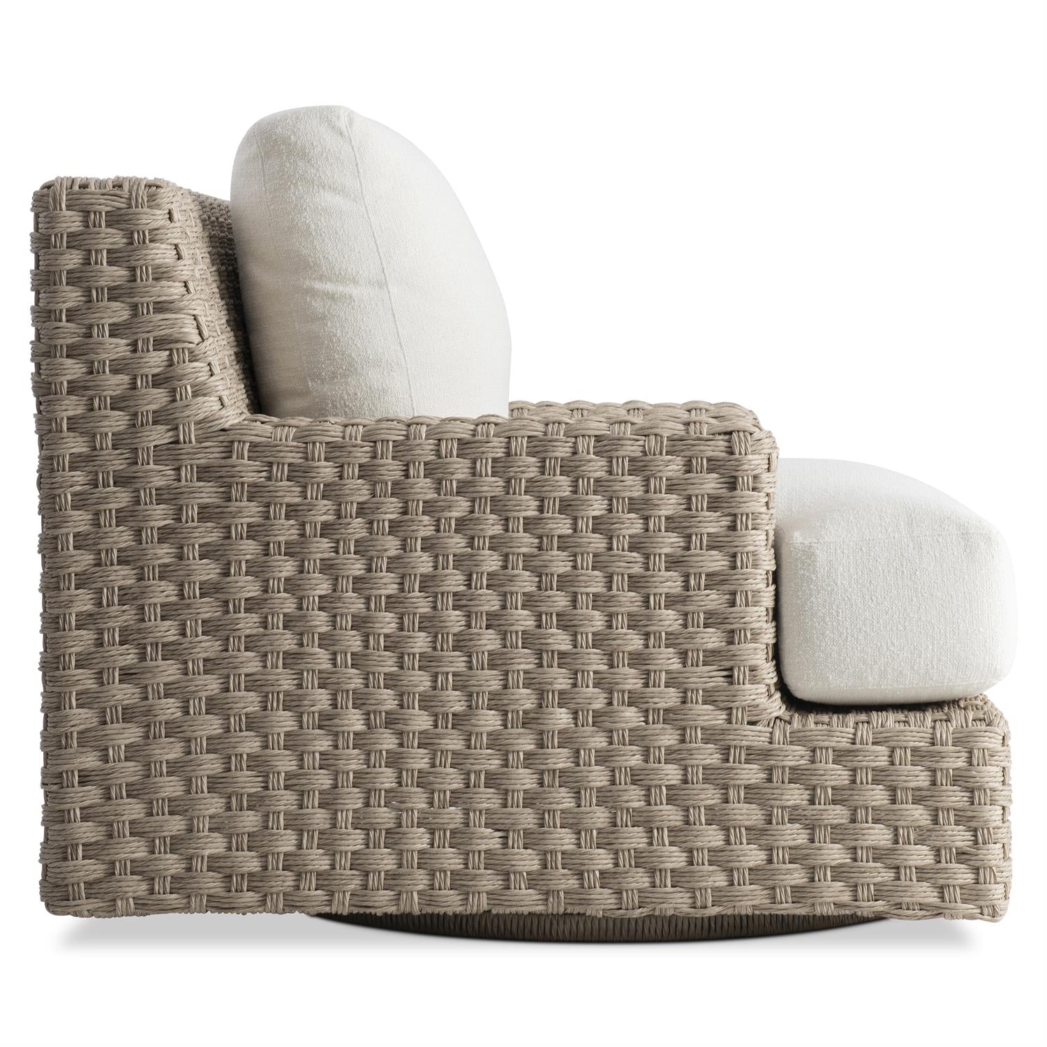 A side profile of an outdoor swivel chair with handwoven all-weather wicker in a Pampas finish. The chair’s deep seat and thick cushions offer exceptional comfort, while the wide armrests enhance support. The base is subtly designed to enable smooth 360-degree movement.