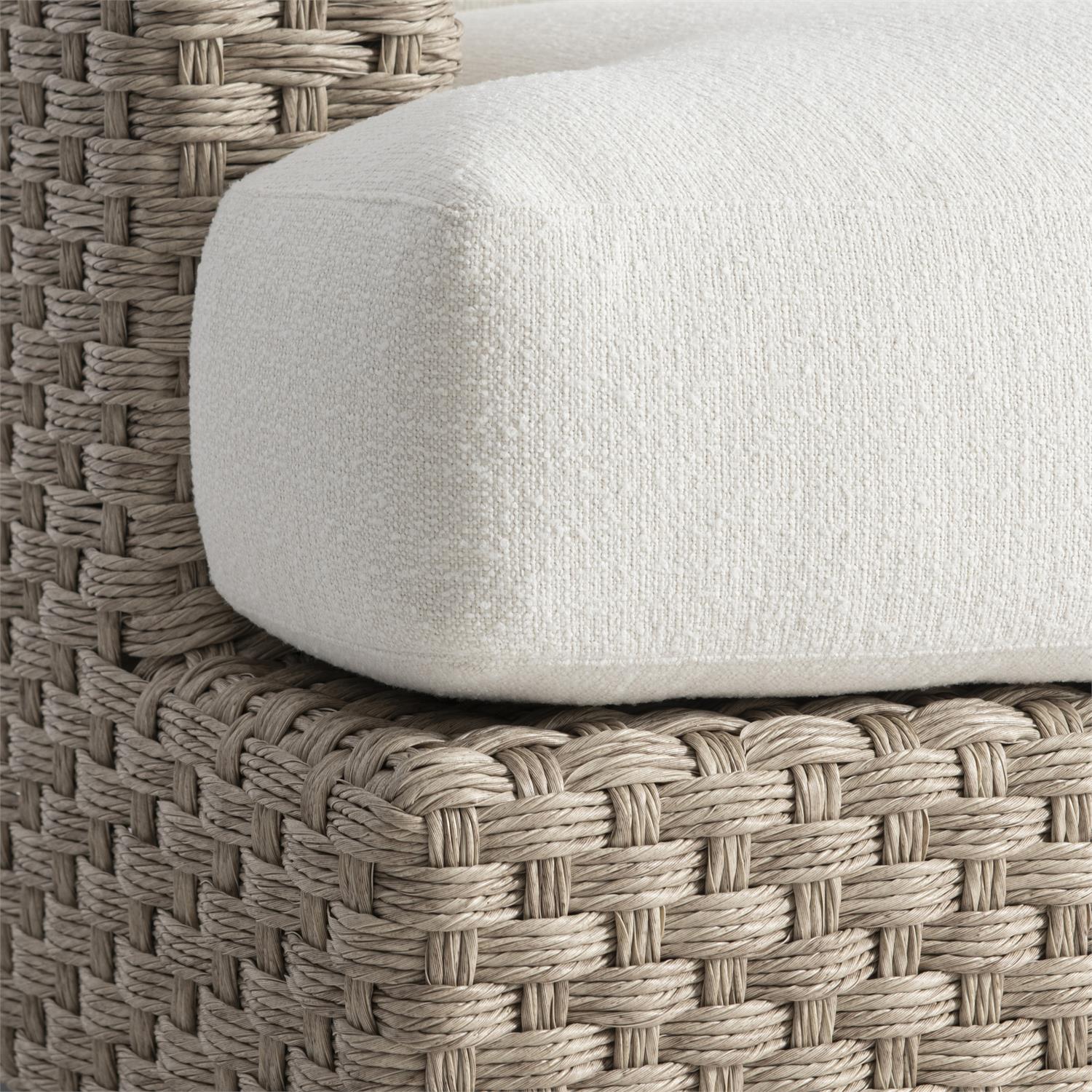 A close-up view of the outdoor swivel chair’s front cushion and woven wicker frame. The plush, T-shaped seat cushion is upholstered in a soft, weather-resistant fabric, offering deep comfort. The tightly handwoven all-weather wicker in a neutral Pampas finish showcases an intricate texture, adding durability and visual appeal to the chair’s design.