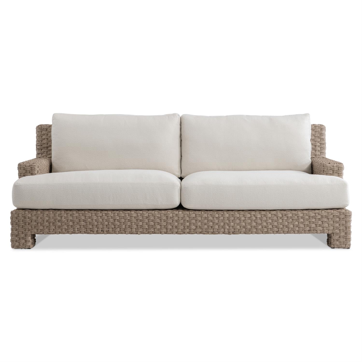 A modern outdoor sofa featuring a deep-weave all-weather wicker frame in a Pampas finish. The design includes wide armrests and plush, weather-resistant white cushions, offering deep comfort and a stylish, inviting look.