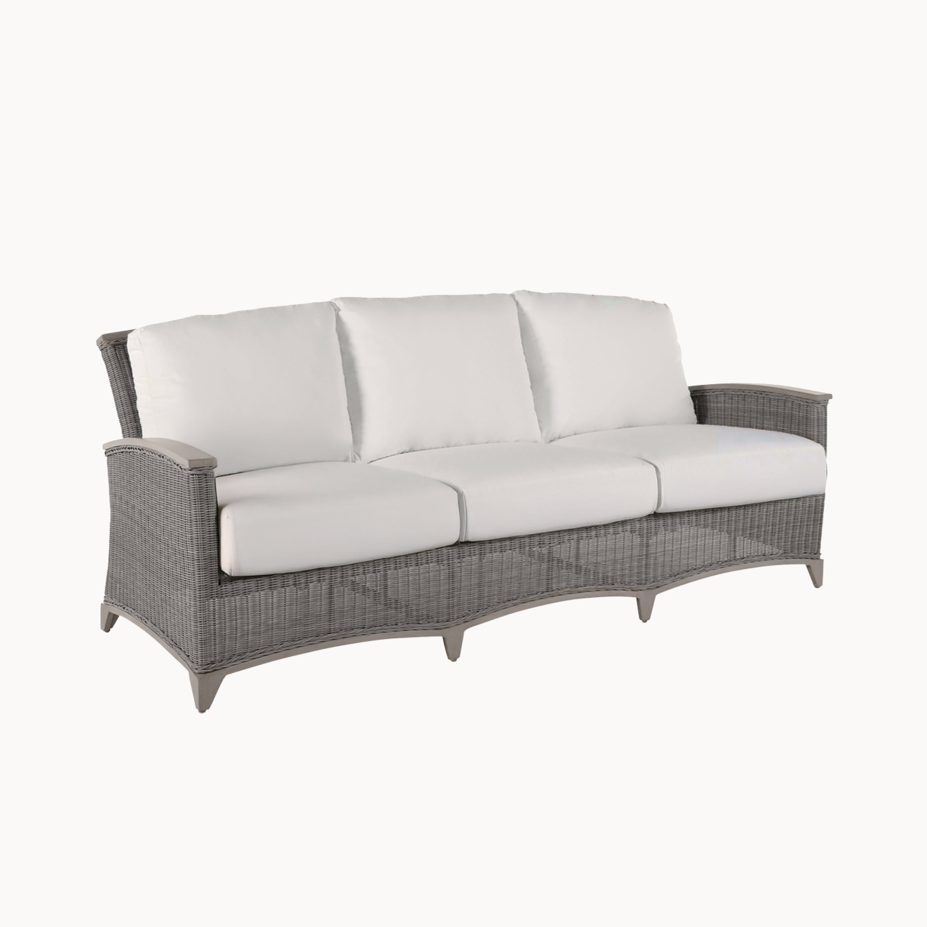 Gray wicker outdoor sofa with white cushions on a white background