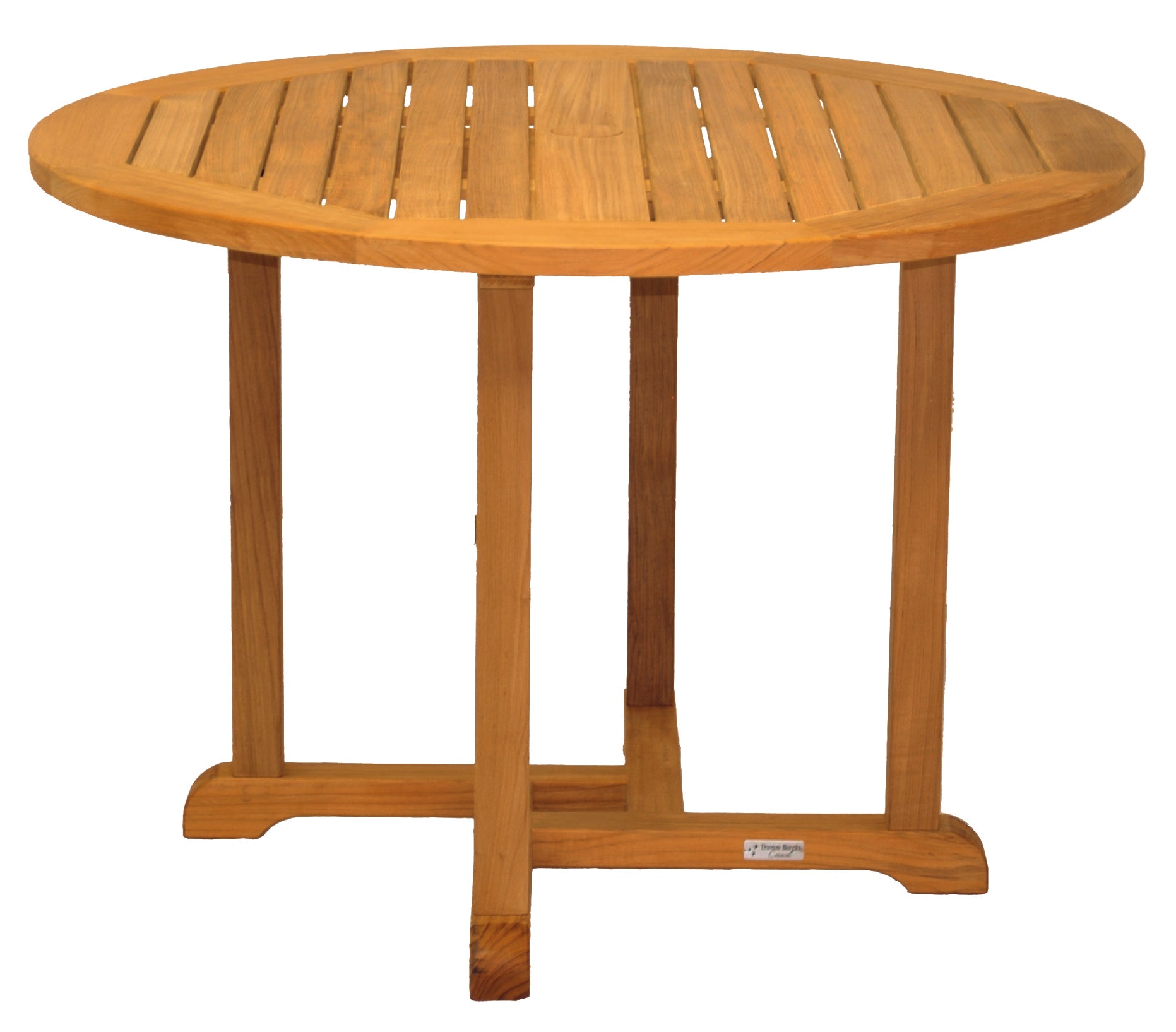 A Three Birds Oxford Teak Round 42" Dining Table set with four matching chairs on a stone patio, with greenery and a stone wall in the background.