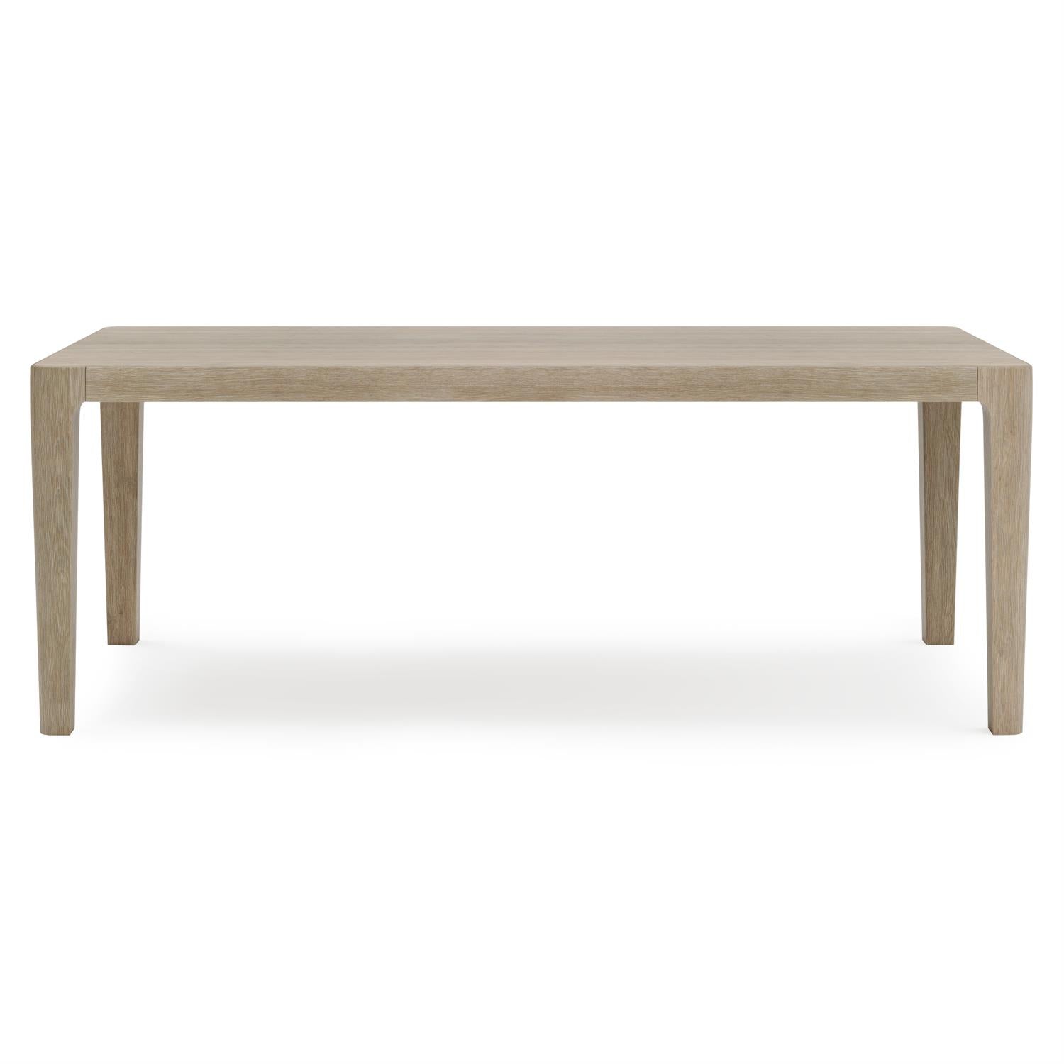 A side profile of the outdoor dining table, emphasizing the minimalist lines, gently tapered legs, and smooth, durable teak construction in a warm Sea Oat tone.
