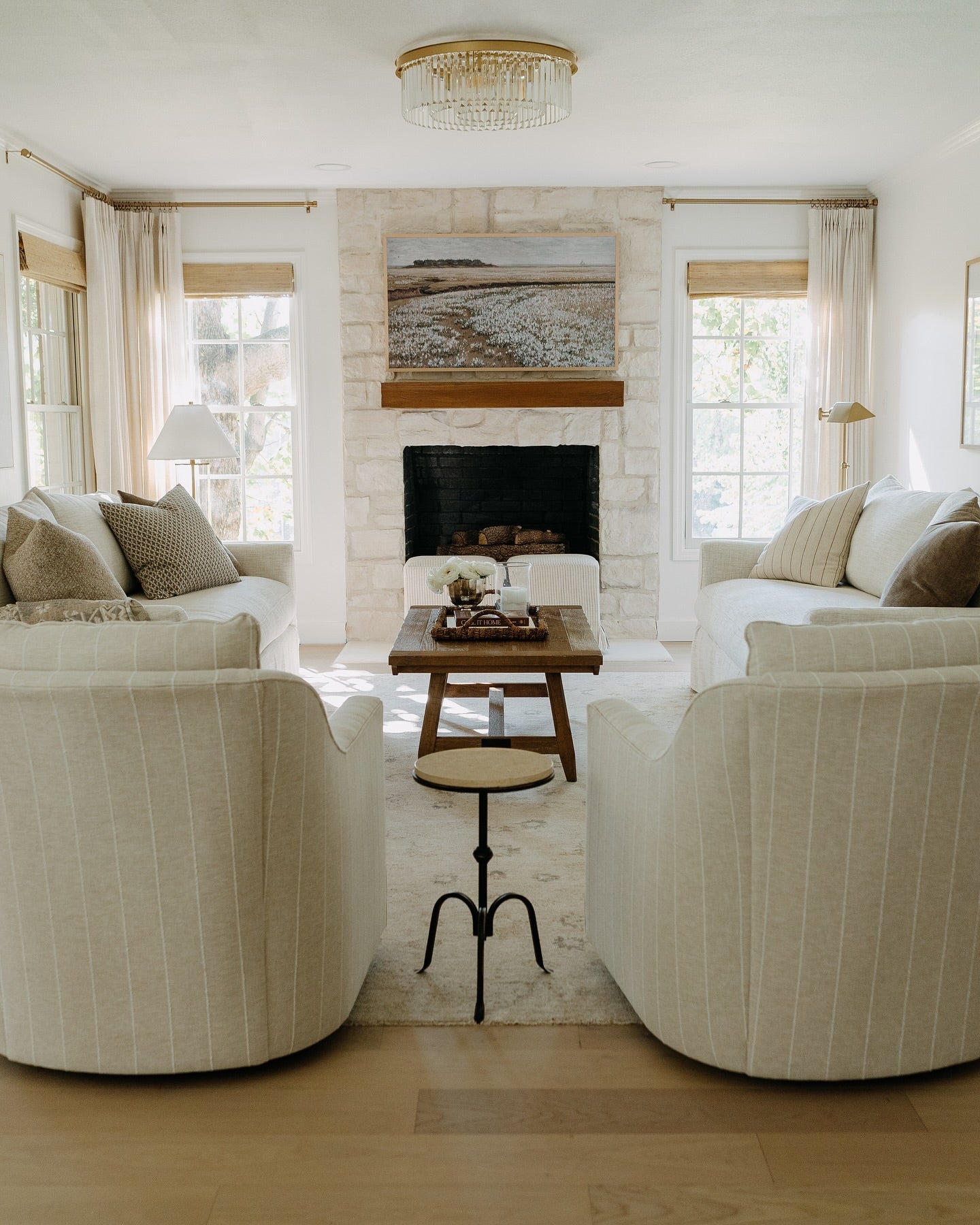Modern living room with white sofas, a fireplace, and decorative elements.