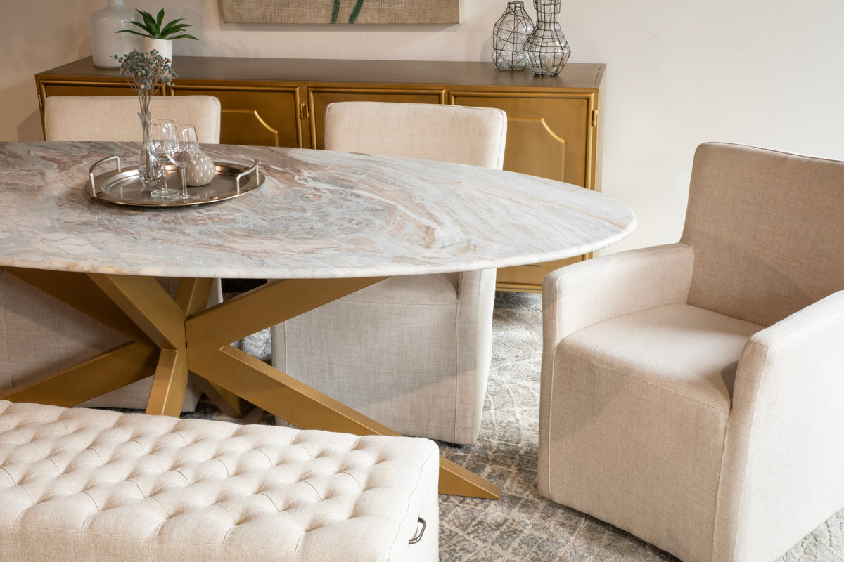 Home Trends & Design marble-top oval dining table with brass base in a styled dining room