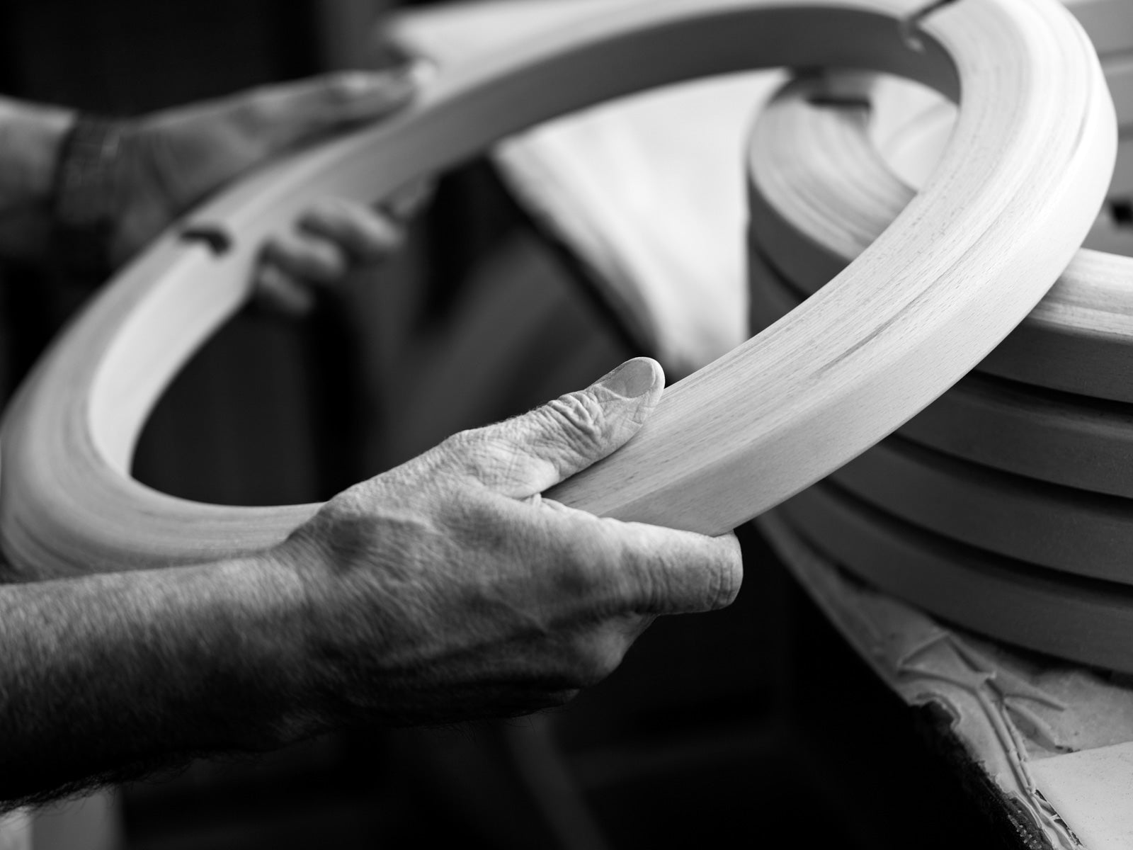 Craftsman hand-shaping a solid beech wood base for a Stressless recliner