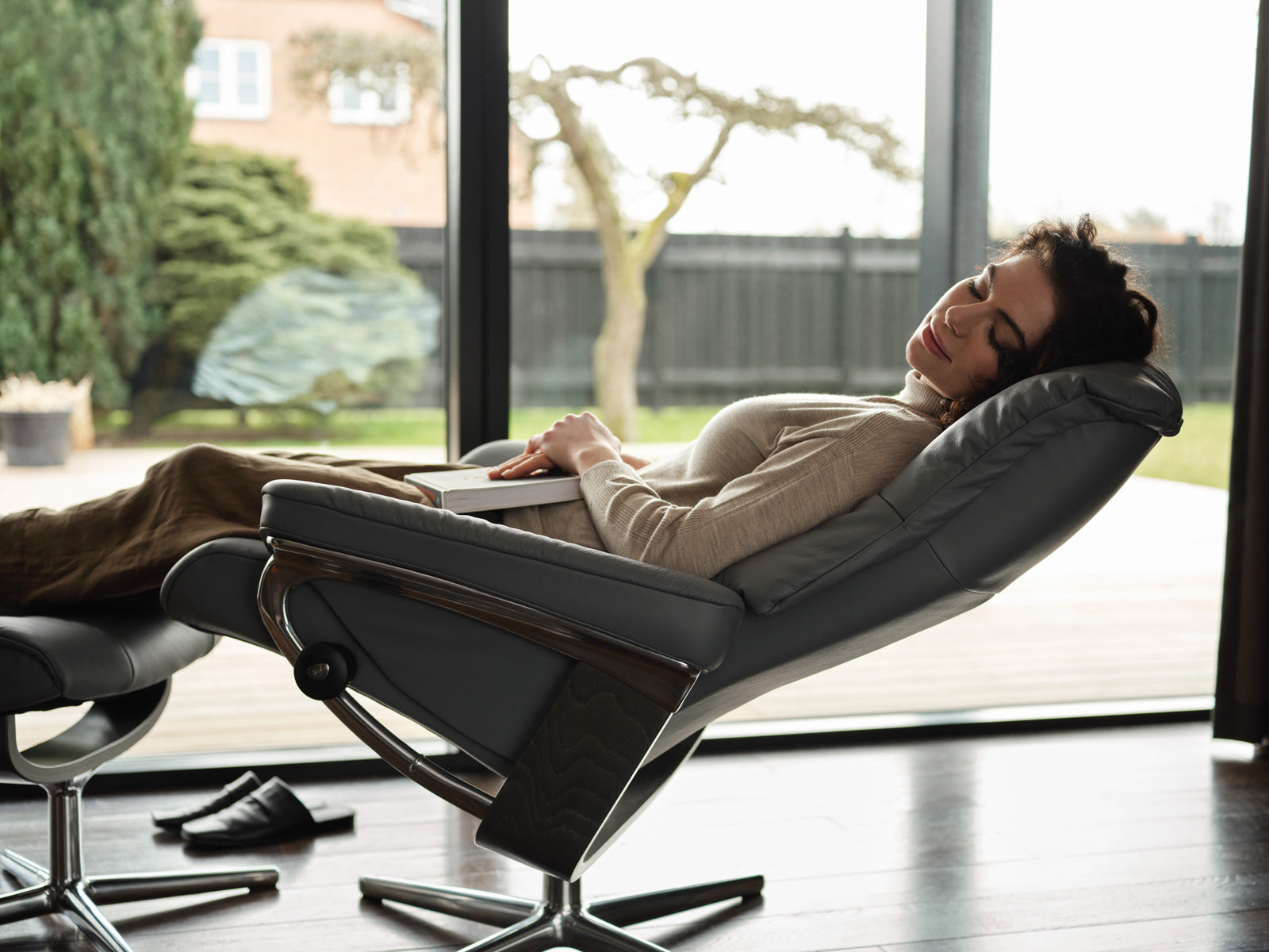 Woman reclining comfortably in a Stressless Mayfair chair, ideal for nursing and breastfeeding