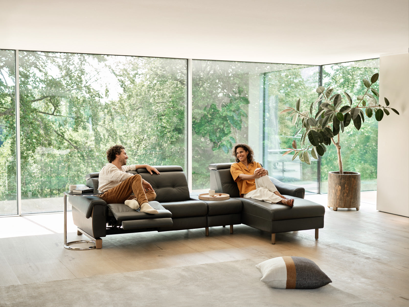 Couple relaxing on a Stressless Anna sectional sofa in a bright modern living room
